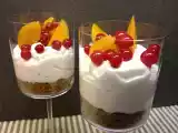 Ricetta Crema di yogurt in bicchiere con fondo di biscotto croccante, ribes e pesche sciroppate