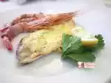 Ricetta Filetto di orata al forno in crosta di patate con code di gamberi avvolti nello speck