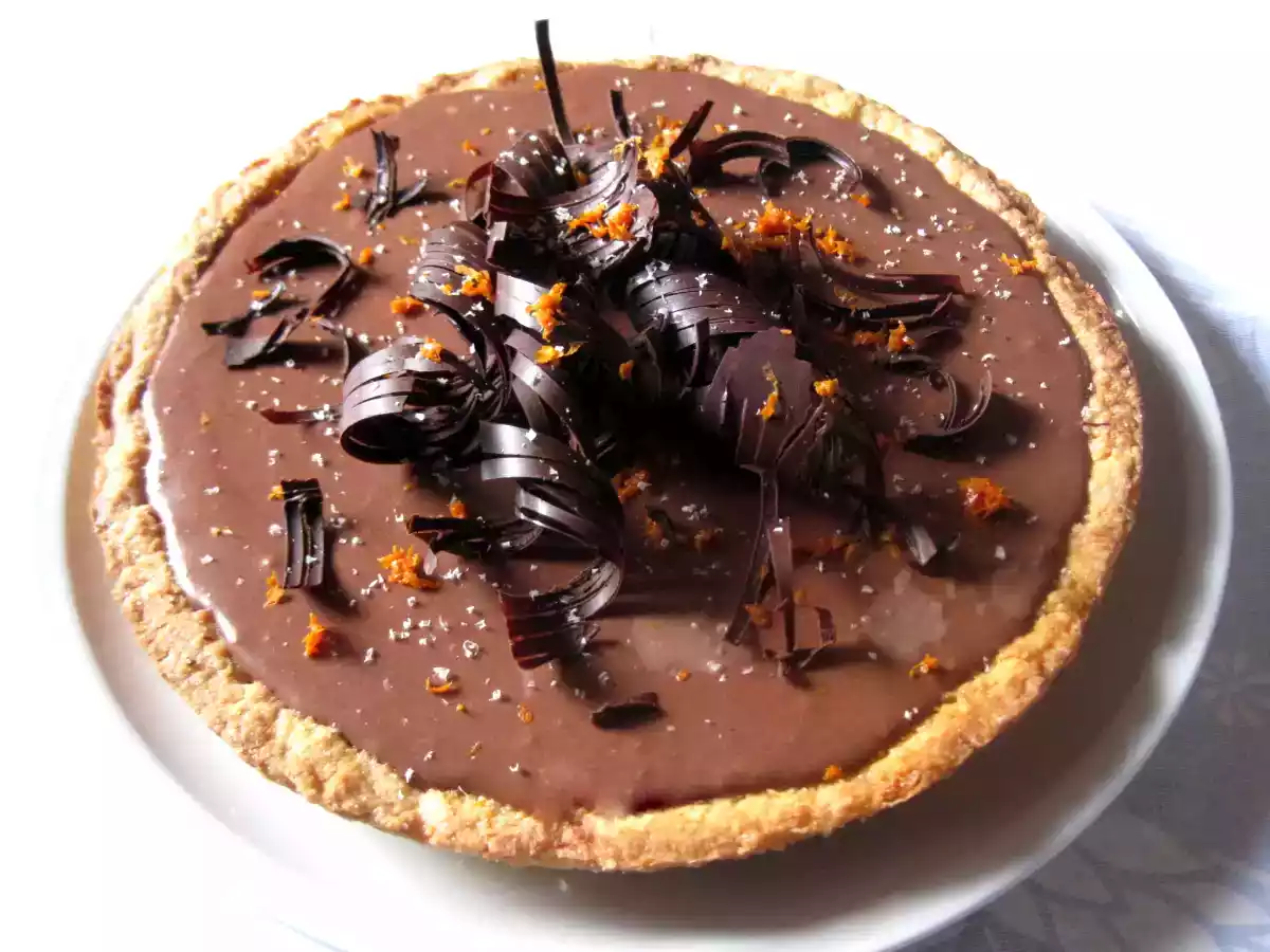 Crostata alle mandorle con fascia bicolore, scorza d' arancia e riccioli di cioccolato